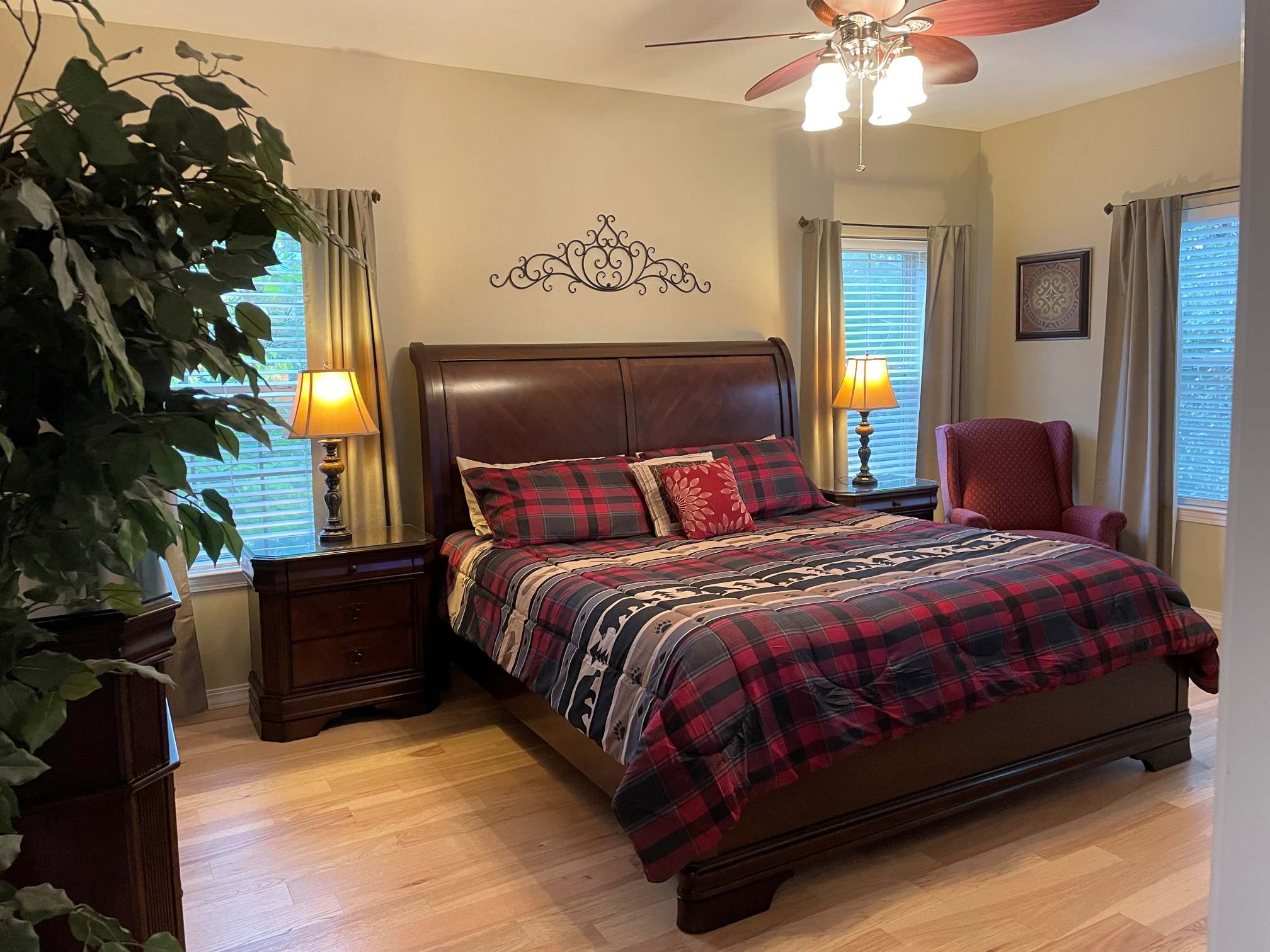 a bedroom with a bed, chair, and ceiling fan