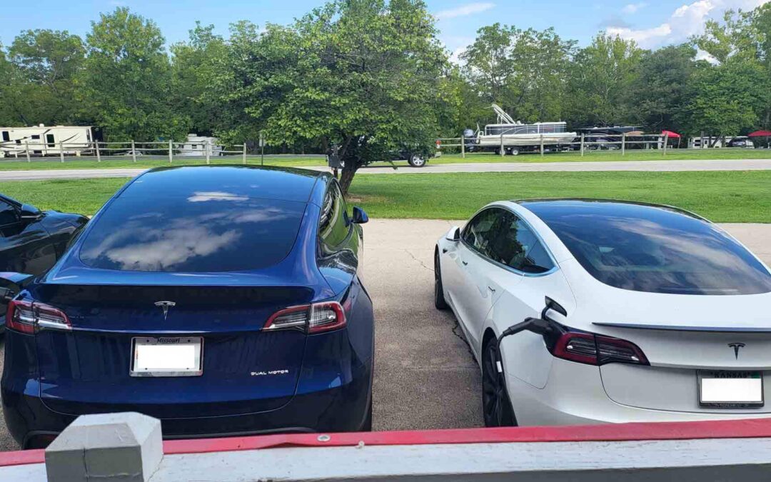 three electric cars are parked in a parking lot