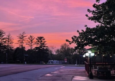 a pink sky is seen over a parking lot