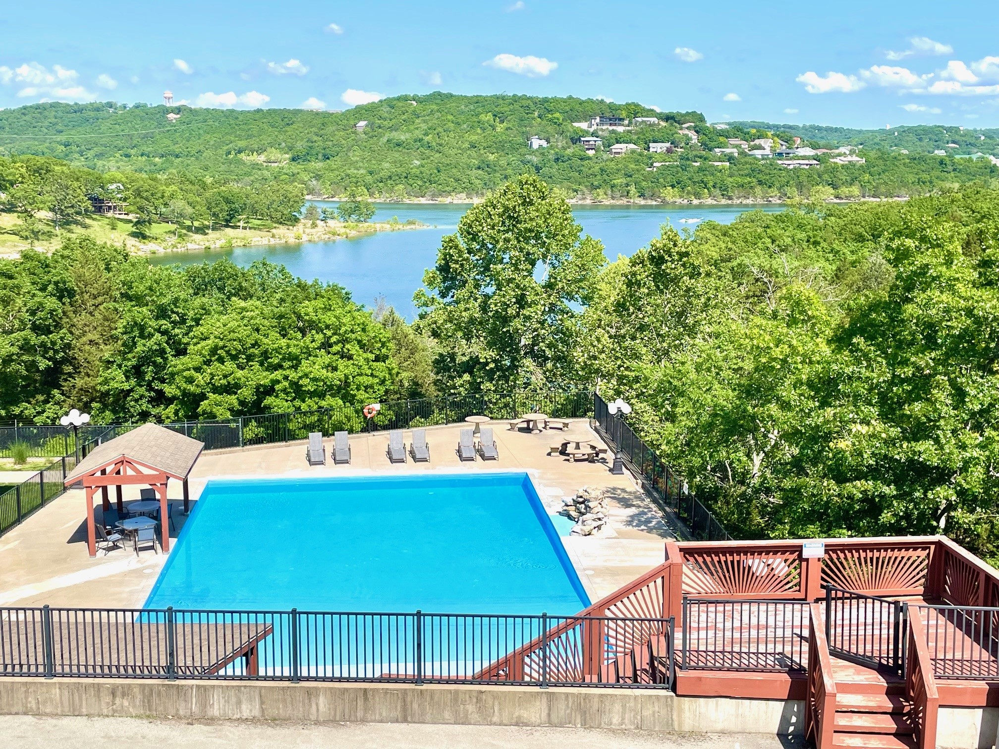 an aerial view of a swimming pool surrounded by trees