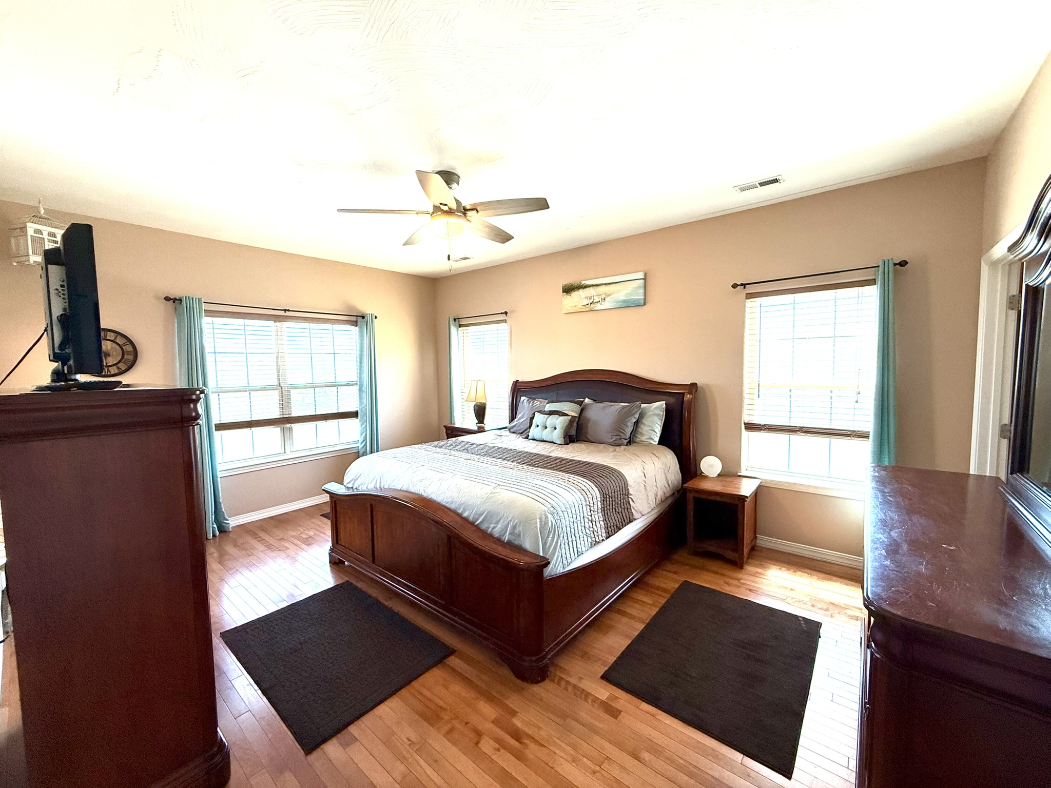 a bedroom with hardwood floors and a bed