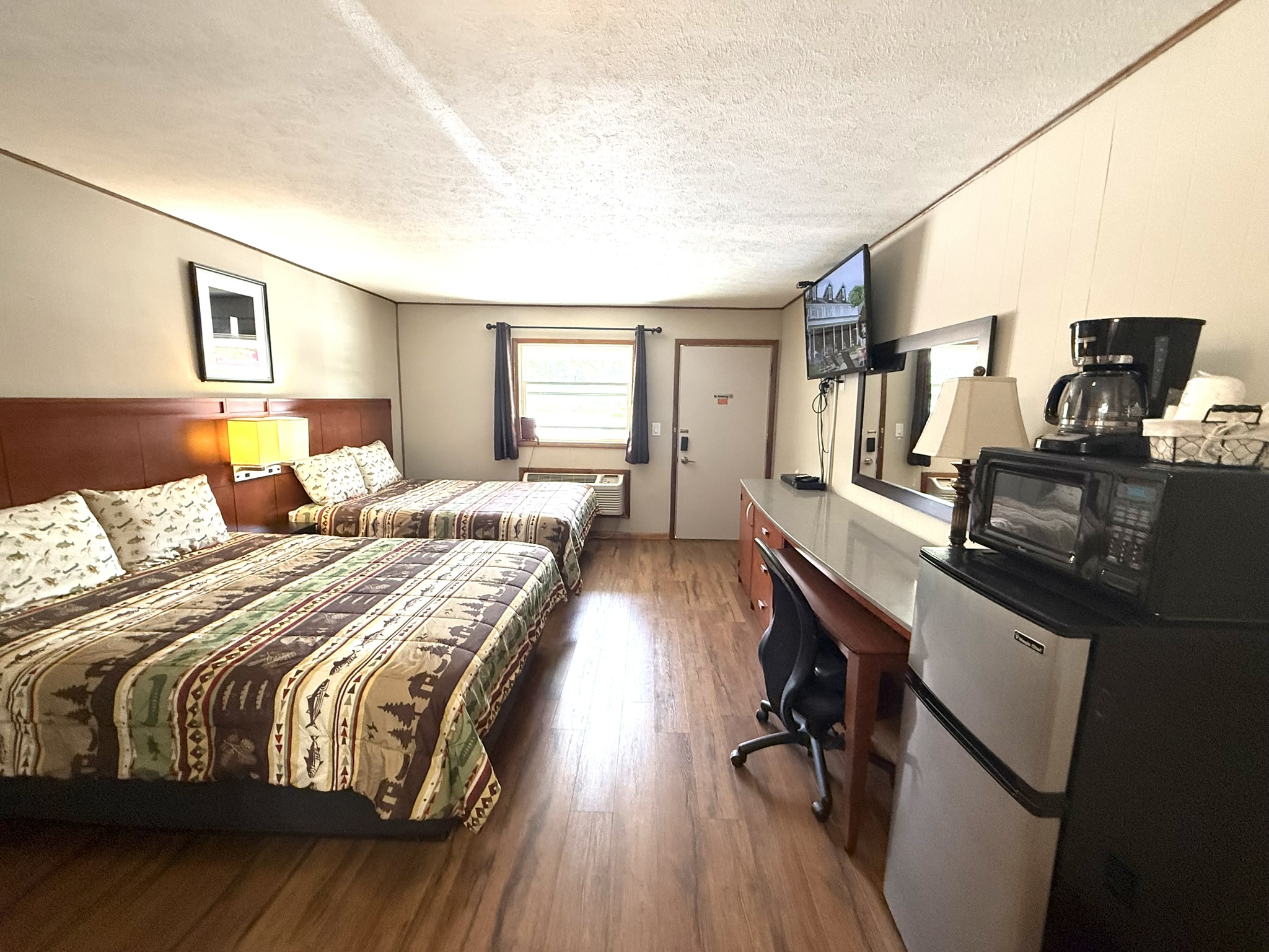 a hotel room with two beds and a refrigerator