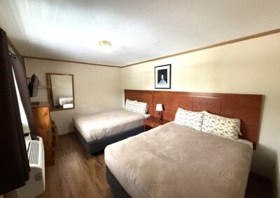 a hotel room with two beds and a fan