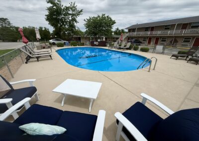 a large swimming pool with lounge chairs around it