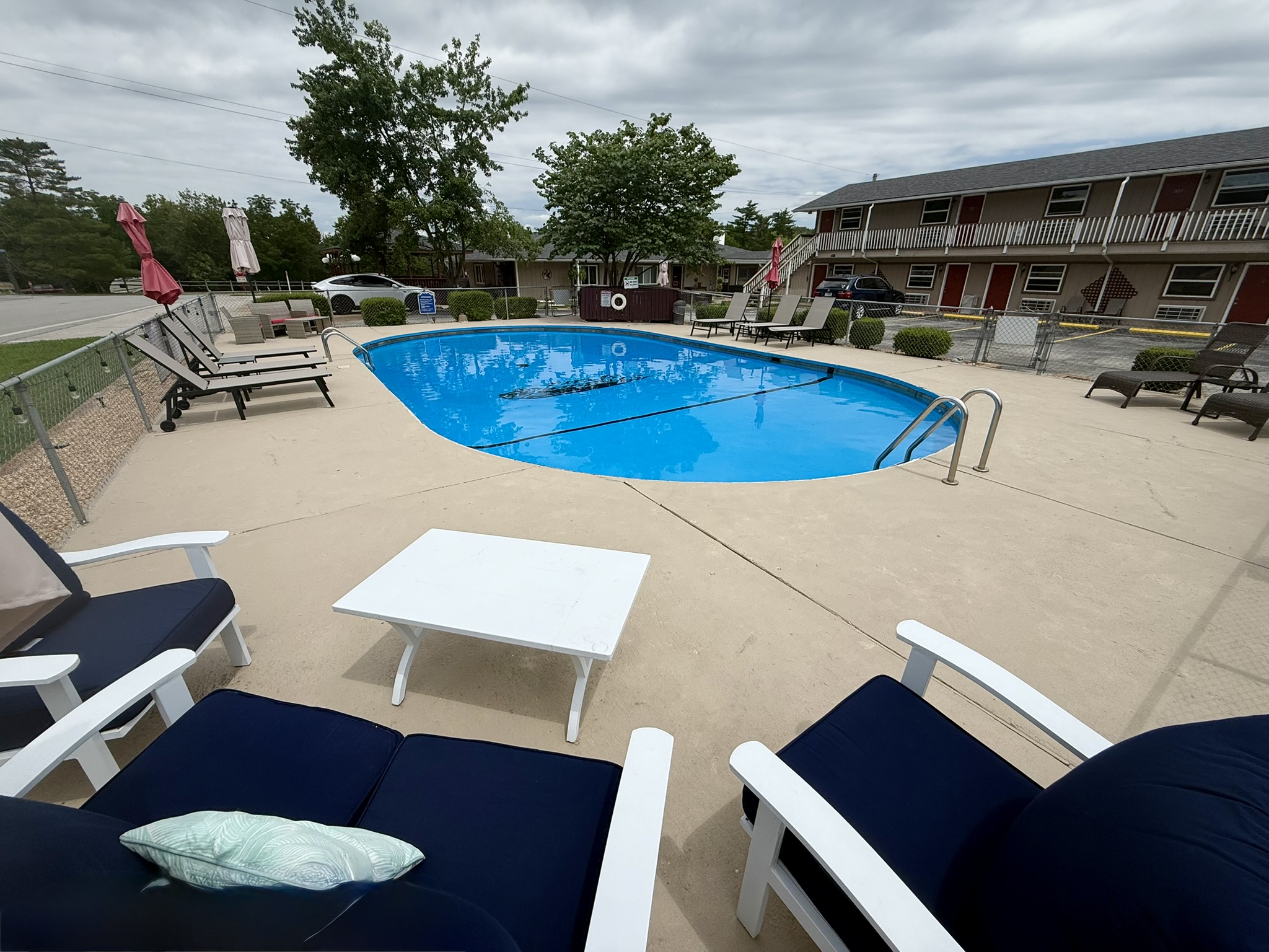 a large swimming pool with lounge chairs around it